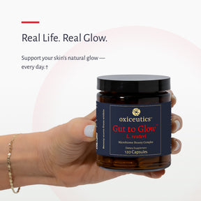 Hand holding a jar of Gut to Glow: Real Life. Real Glow.